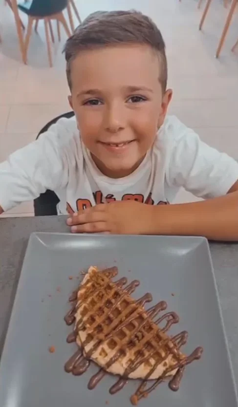 Un nen somrient davant d'un gofre proteic de Cuida't