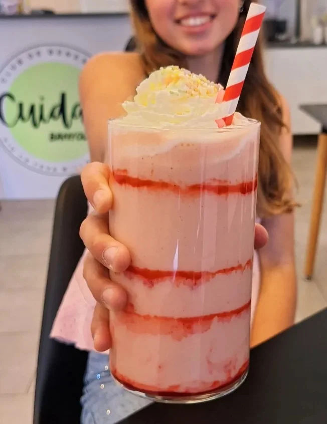 Una noia oferint el seu batut de Cuida't Banyoles a càmera
