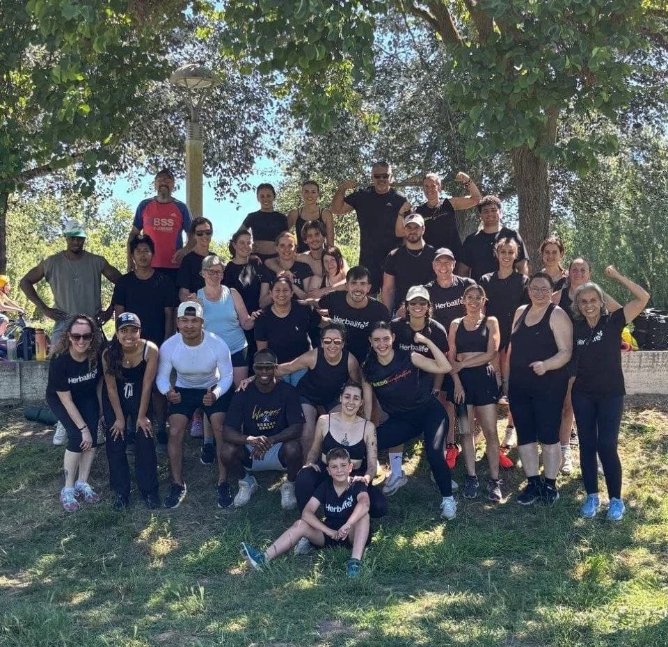 Grup de Social FitCamp Banyoles junts sota els pollancres del parc, després d’una sessió